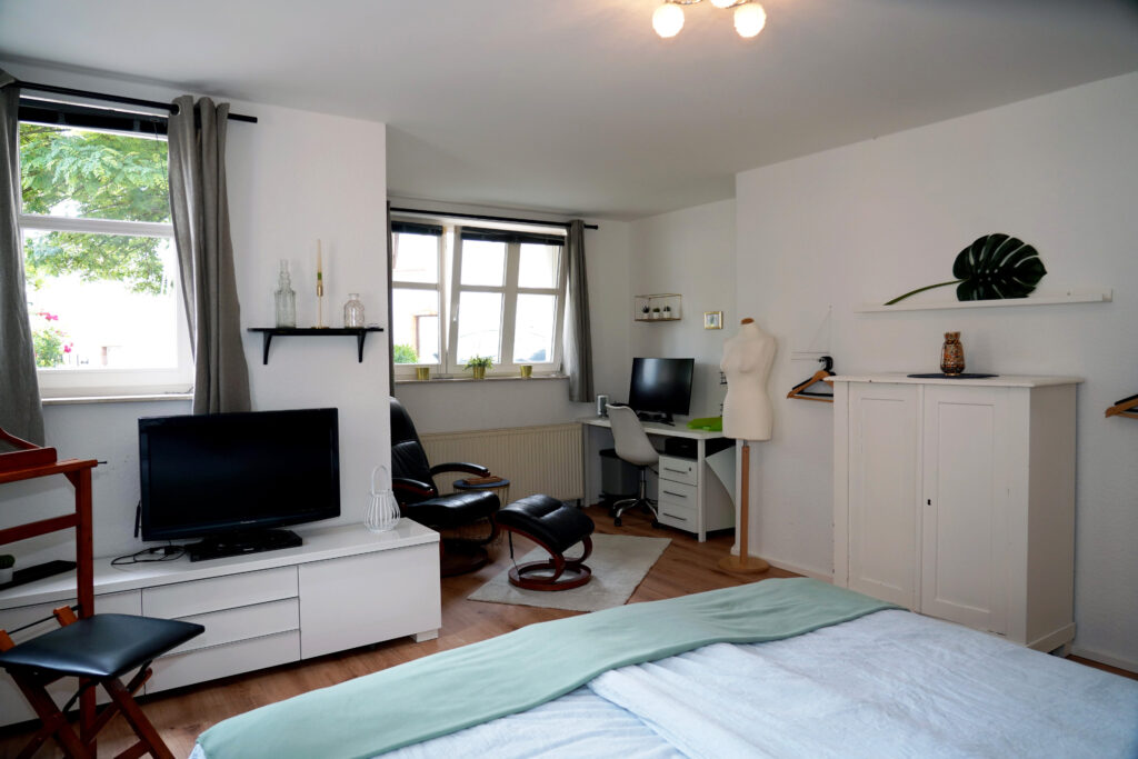 Grosses Schlafzimmer mit Massage-Sessel und Arbeitsplatz